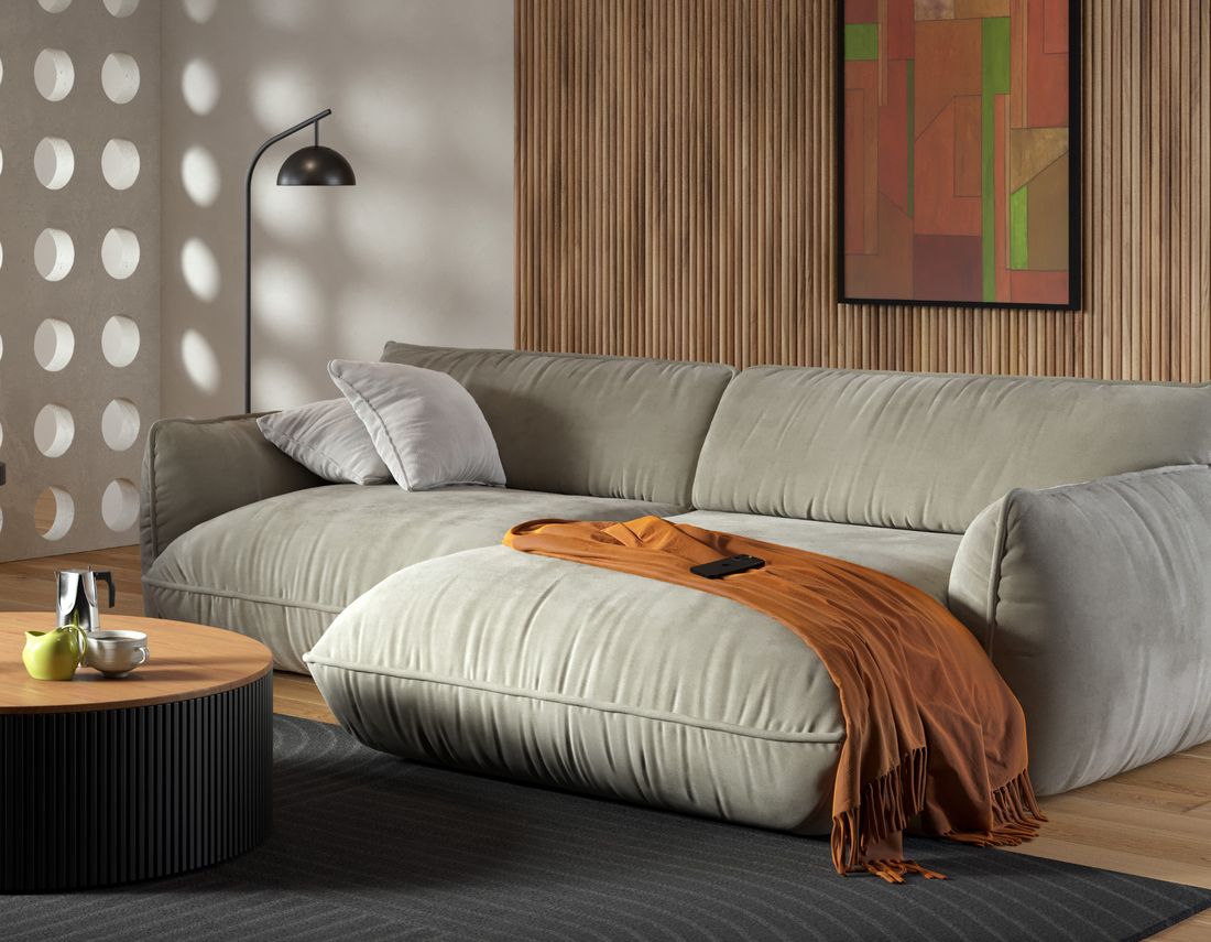 Modernes Wohnzimmer mit beigem Sofa, orangefarbener Decke, rundem Couchtisch und abstrakter Wandkunst.